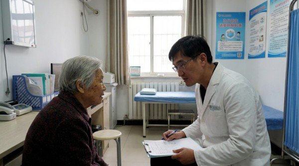 穿著白袍的吳紹琥醫師正在思索弱勢醫療現況 偏鄉診間裡展現弱勢醫療急需改善的資源缺口 象徵公平正義的醫療天平支撐著弱勢醫療平權